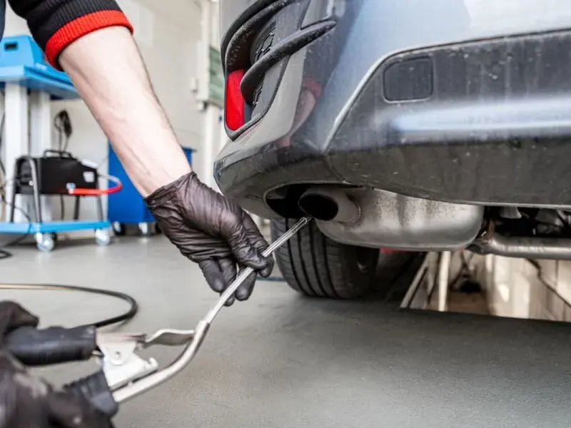 Abgassonde wird für die Abgasuntersuchung in den Auspuff eines Fahrzeugs eingeführt