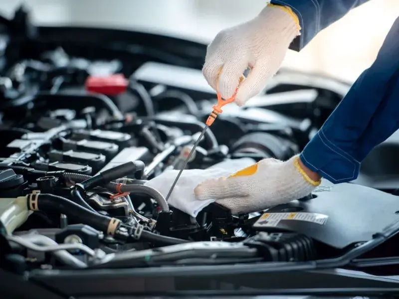 Ölmessstab wird bei geöffneter Motorhaube geprüft